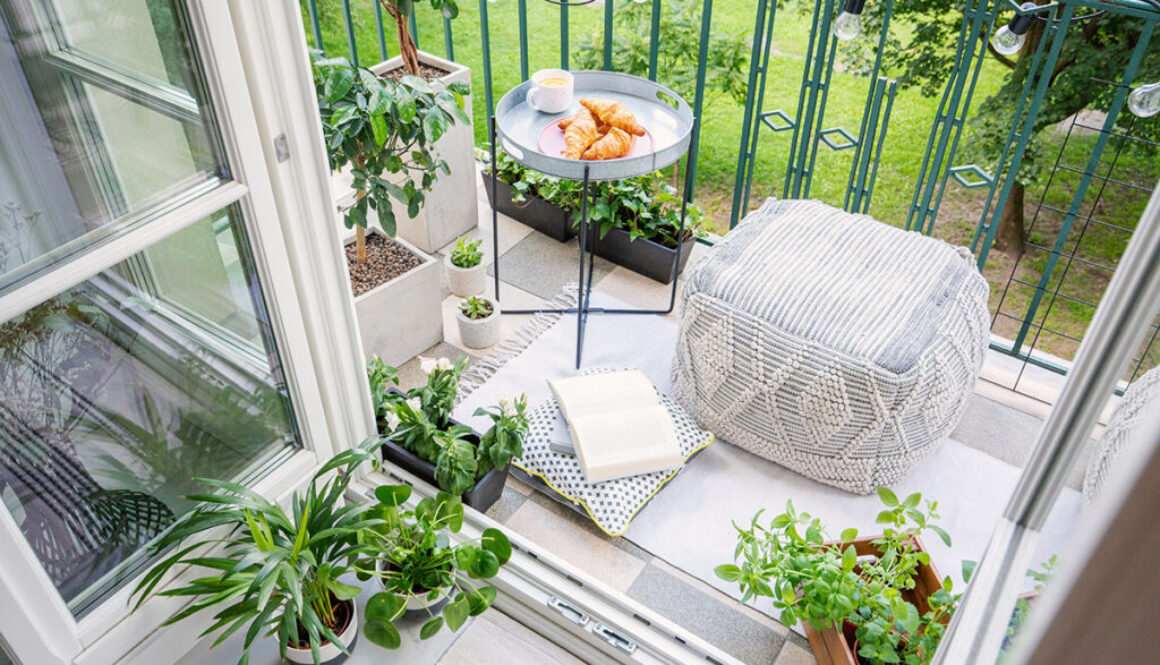 Top view of a balcony with plants, pouf a table with breakfast